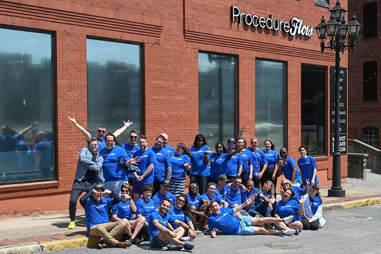 Procedureflow Team with Lit Sign and T-shirts Branded with Procedureflow Logo